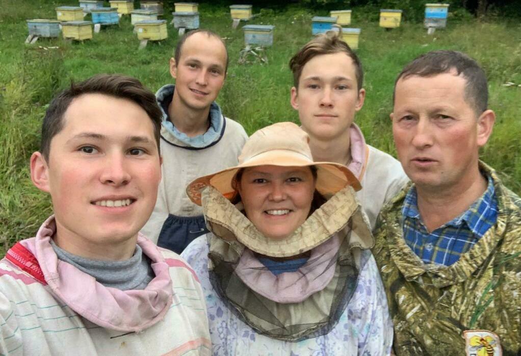 Виталий Савельев с семьёй на фоне пчелохозяйства